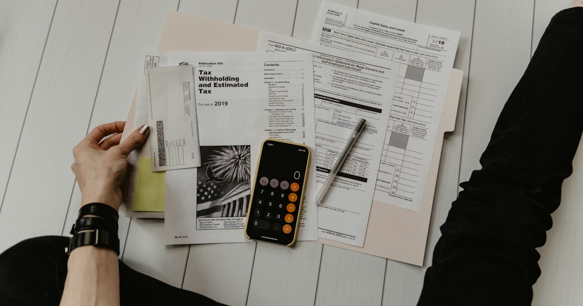 Calculadora y documentos financieros sobre un escritorio para estimar el impuesto vehicular