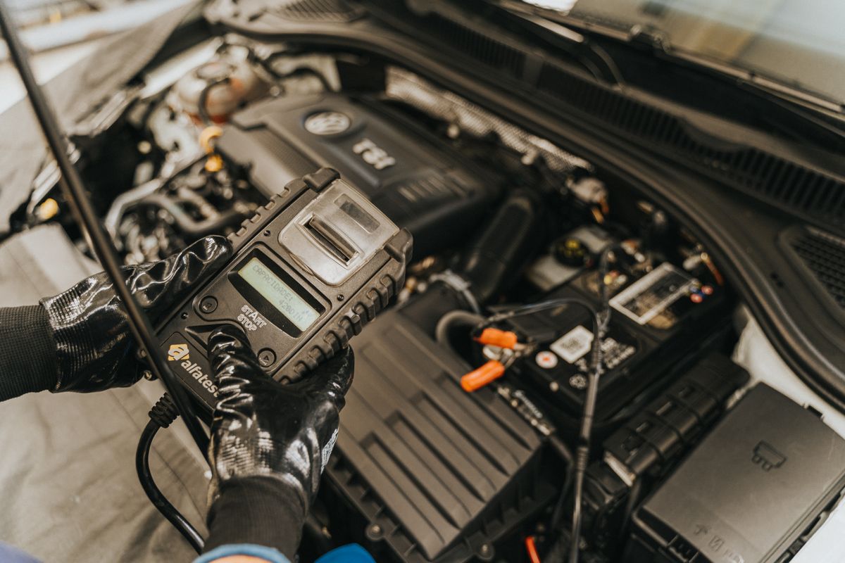 Mecánico inspeccionando el motor de un carro usado en un taller
